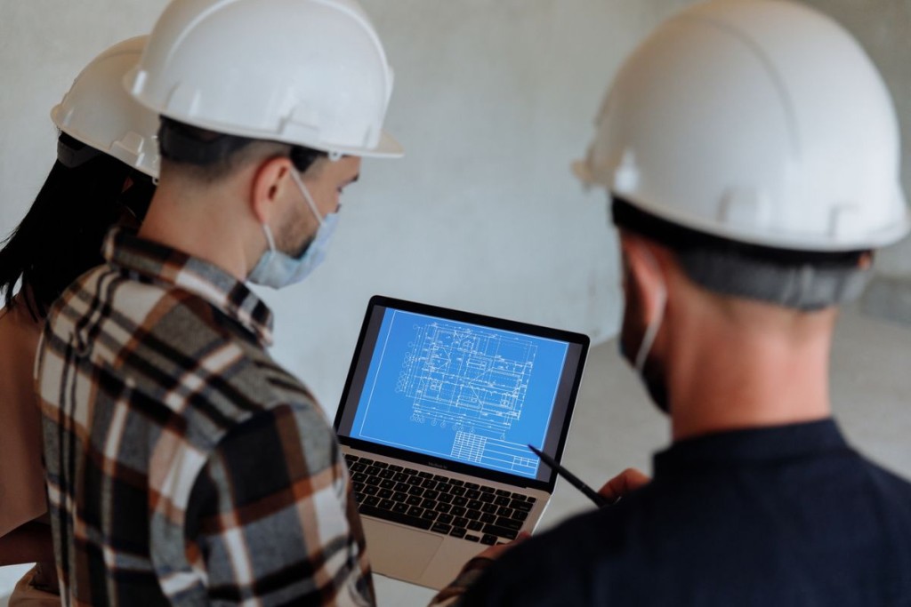BIM Manager: qué hace, qué competencias necesita y por qué es un perfil clave en construcción Profesionales de construcción revisando planos digitales en un portátil