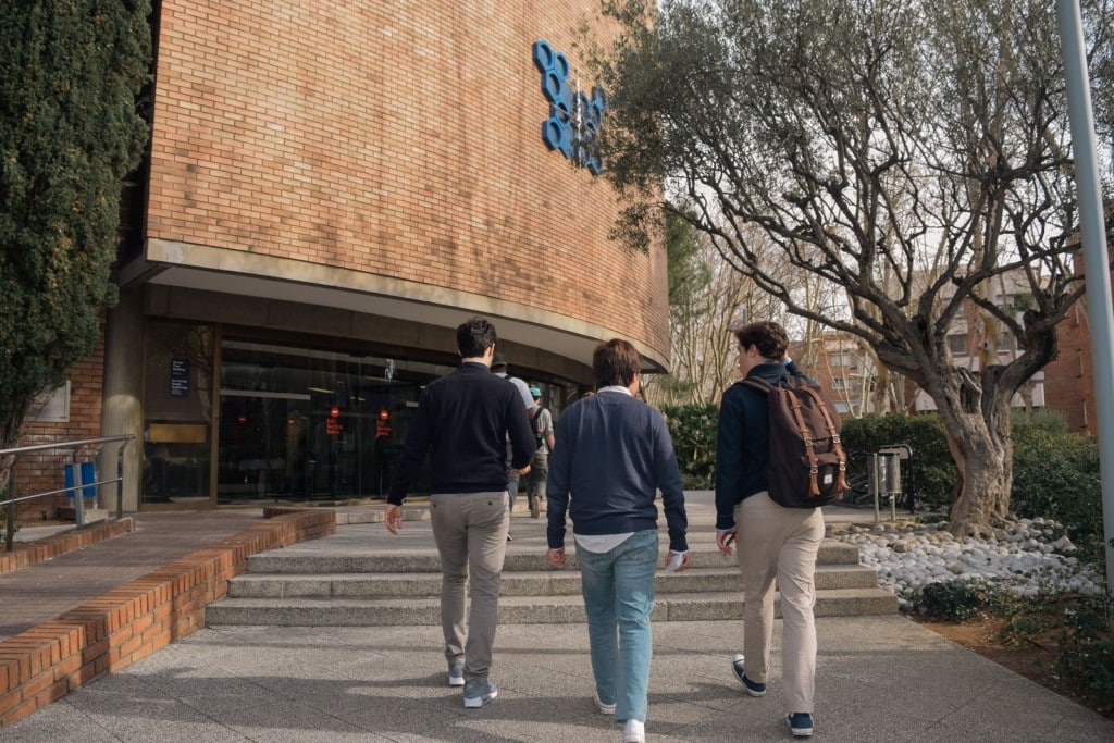 Coste de vida en España para estudiantes: gastos al mes 2026 Estudiantes entrando en un edificio universitario en Barcelona