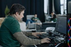 Profesional de informática programando en un ordenador en la oficina