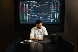 Profesional analizando gráficos financieros en un ordenador portátil