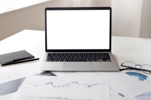 ¿Vale la pena estudiar un MBA online en 2026? Análisis, salarios y ventajas Ordenador portátil y documentos financieros sobre una mesa de trabajo
