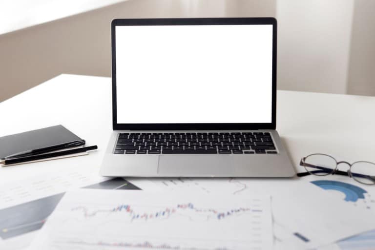 ¿Vale la pena estudiar un MBA online en 2026? Análisis, salarios y ventajas Ordenador portátil y documentos financieros sobre una mesa de trabajo
